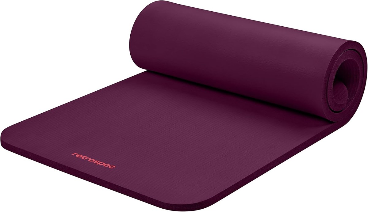 Retrospec Solana 1-inch thick yoga mat in Boysenberry color, partially rolled showing foam thickness